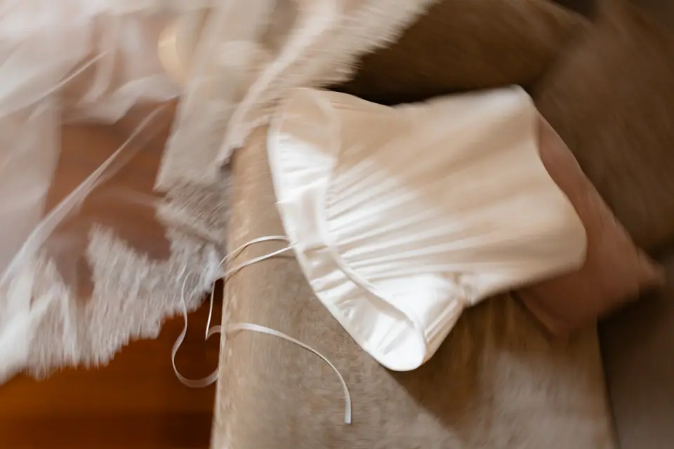 Close-up of a white bow on Sivitha’s shoe beside the lace edge of her veil