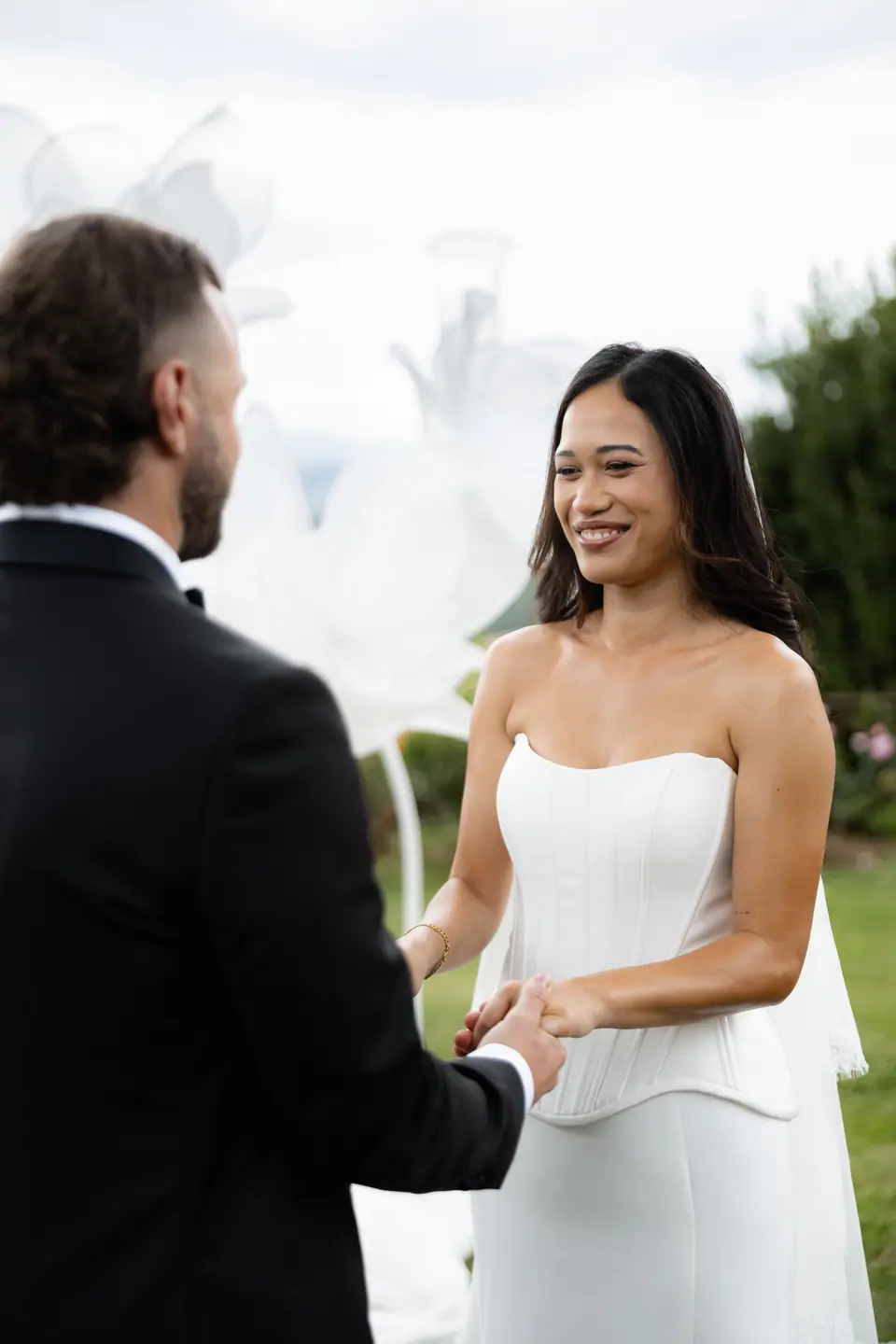 Sivitha smiling at Rory as they hold hands at the ceremony