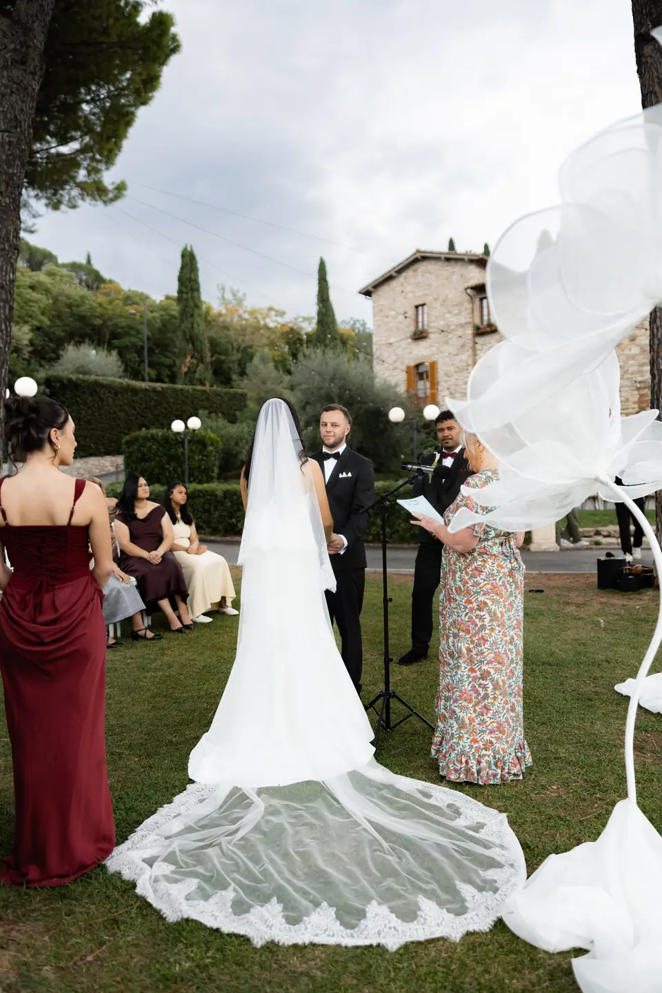 Sivitha’s long lace-edged veil spread over the grass at the ceremony
