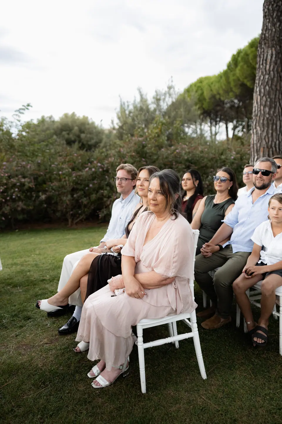 Guests in the front row watching the ceremony in the garden