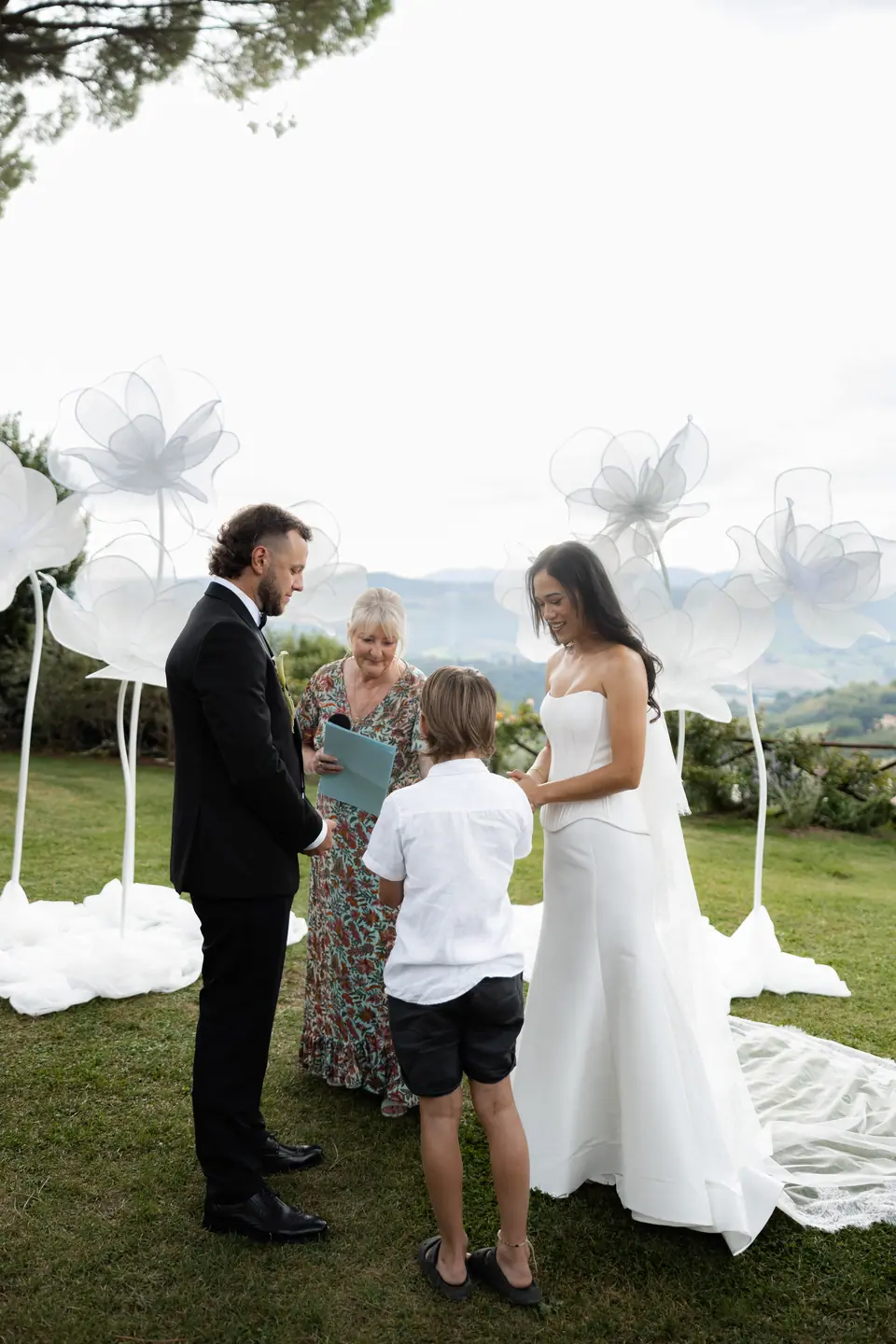 A small boy bringing the rings to Sivitha and Rory beside the celebrant