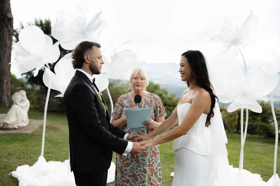 Sivitha and Rory holding hands during their outdoor ceremony
