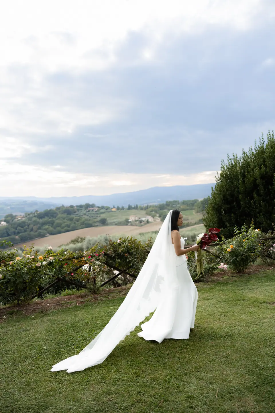 Sivitha walking across the lawn with her veil trailing, the valley behind
