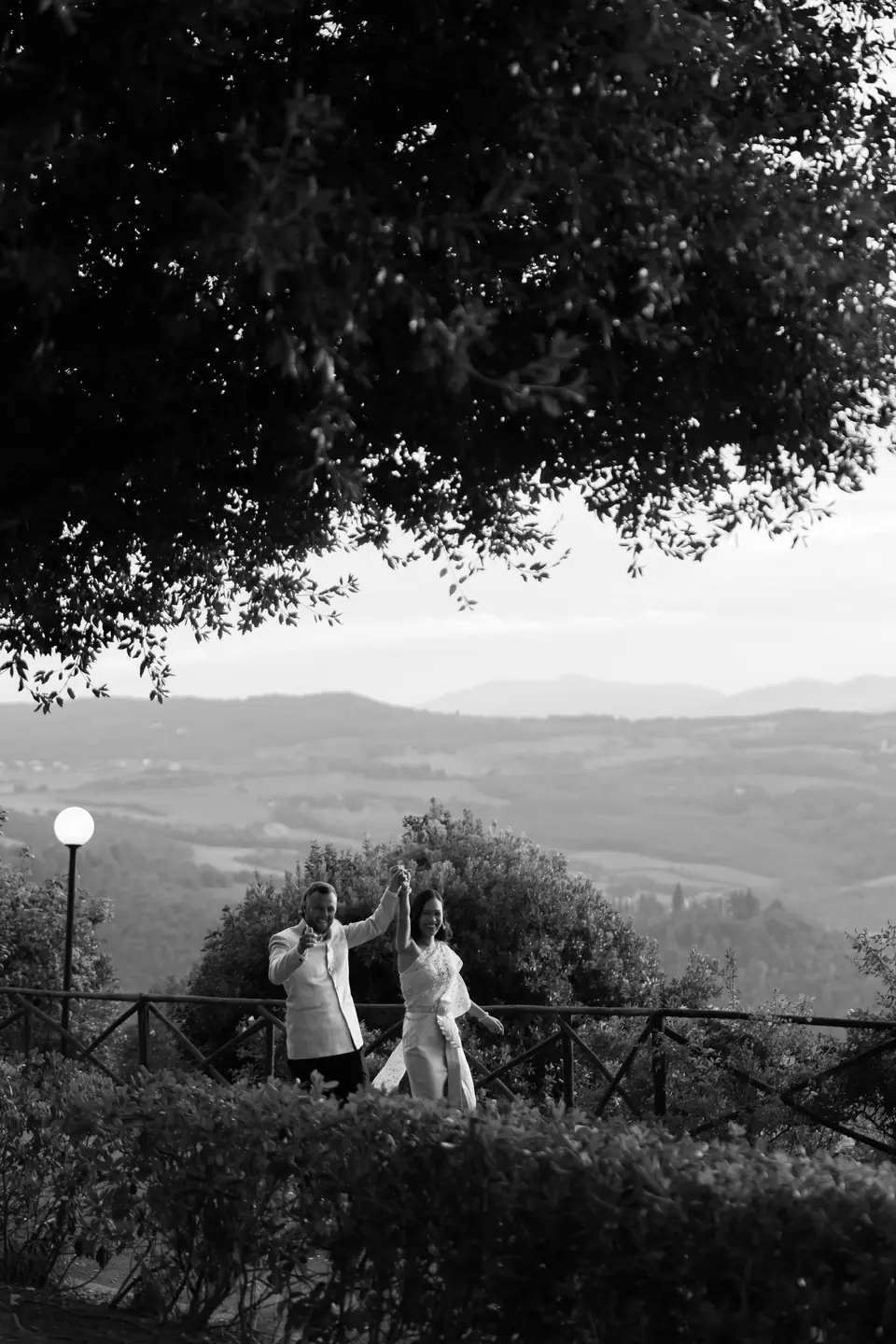 Black and white photograph of Sivitha and Rory dancing their way in above the valley