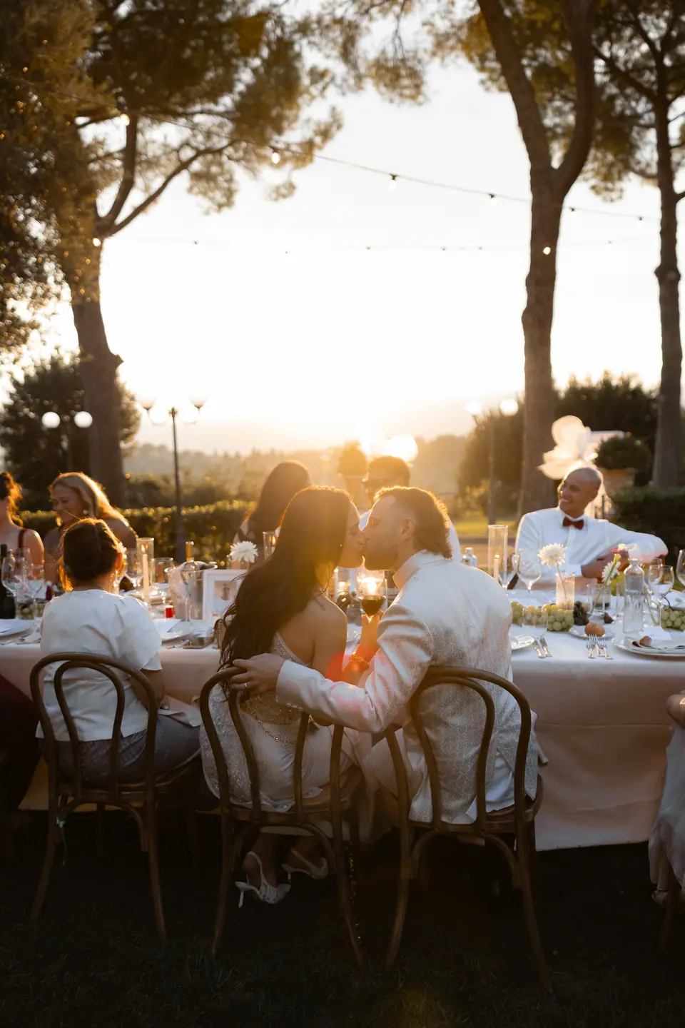 Sivitha and Rory sharing a moment at the table as the sun sets through the pines