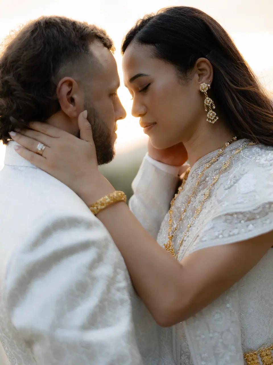 Rory cradling Sivitha’s face as they rest their foreheads together in golden light