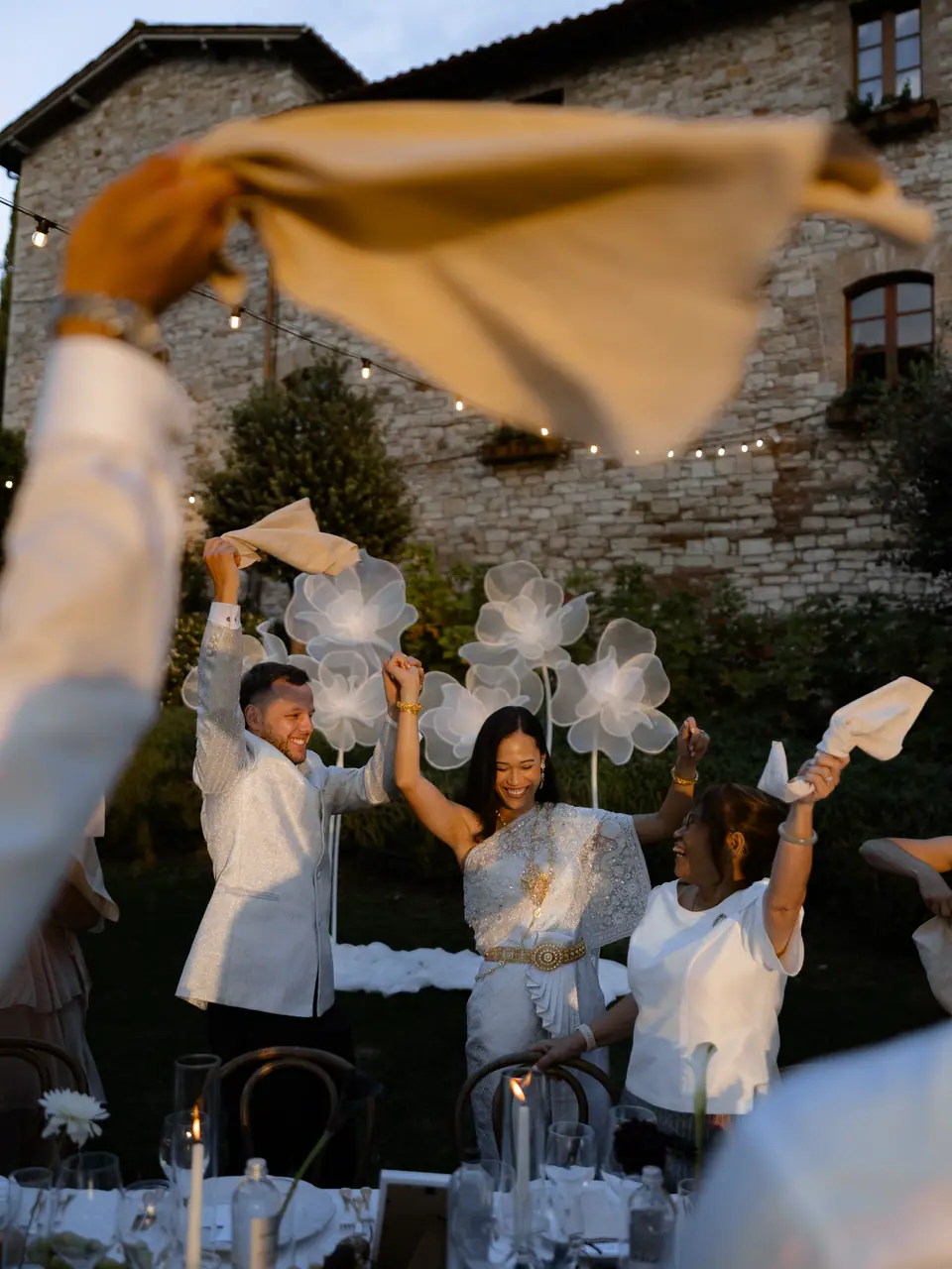 Sivitha and Rory dancing in as napkins swirl above the guests
