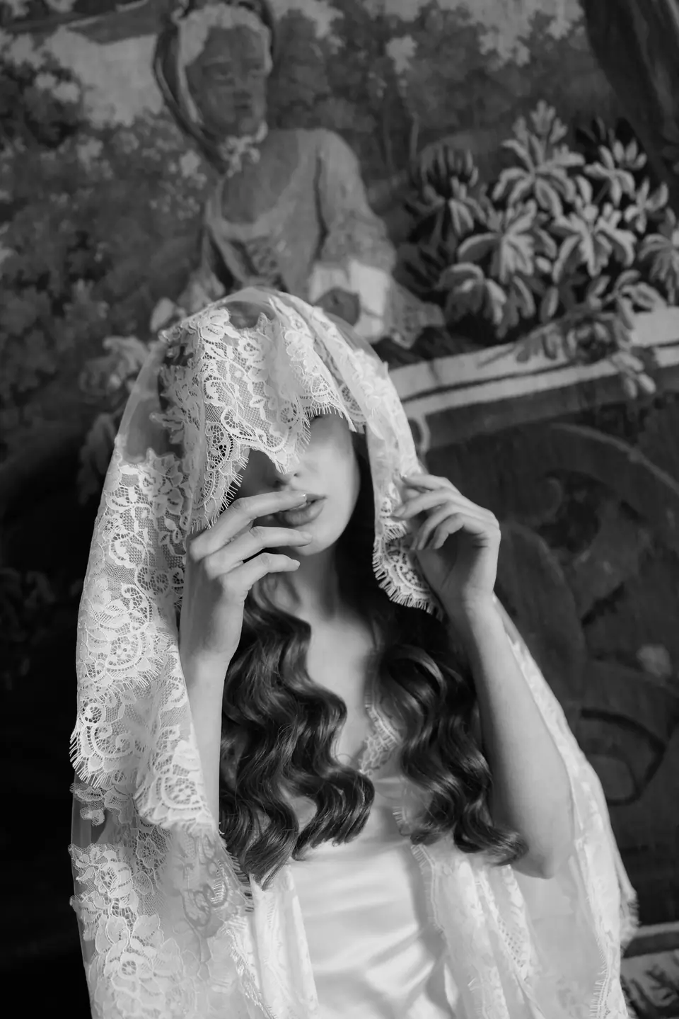 Roberta in black and white drawing a lace veil over her face
