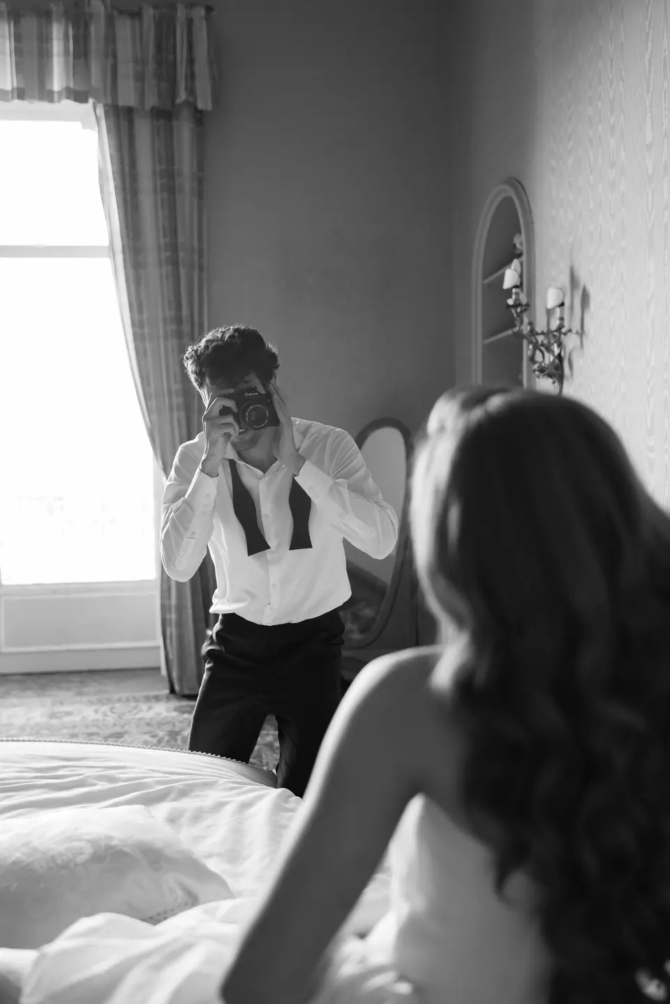 Antoine photographing Roberta in black and white by the bedroom window