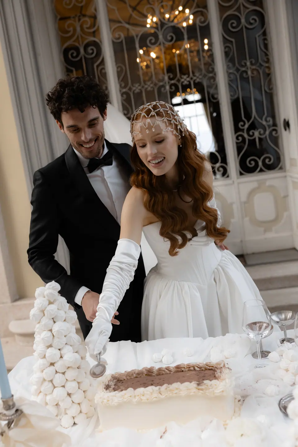 Antoine and Roberta spooning a dessert from a table of meringues and tiramisu