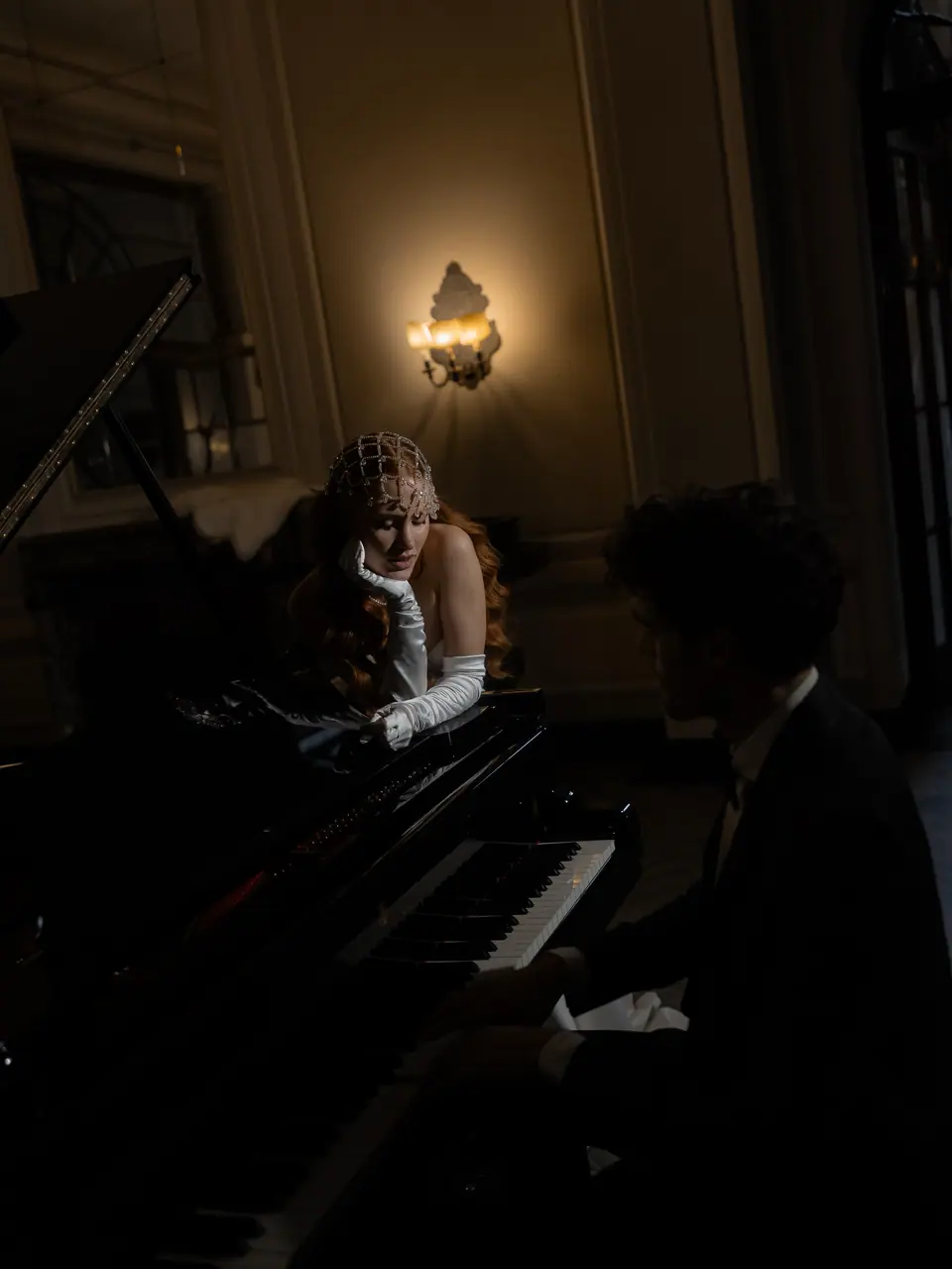Roberta and Antoine at the piano in a dimly lit room