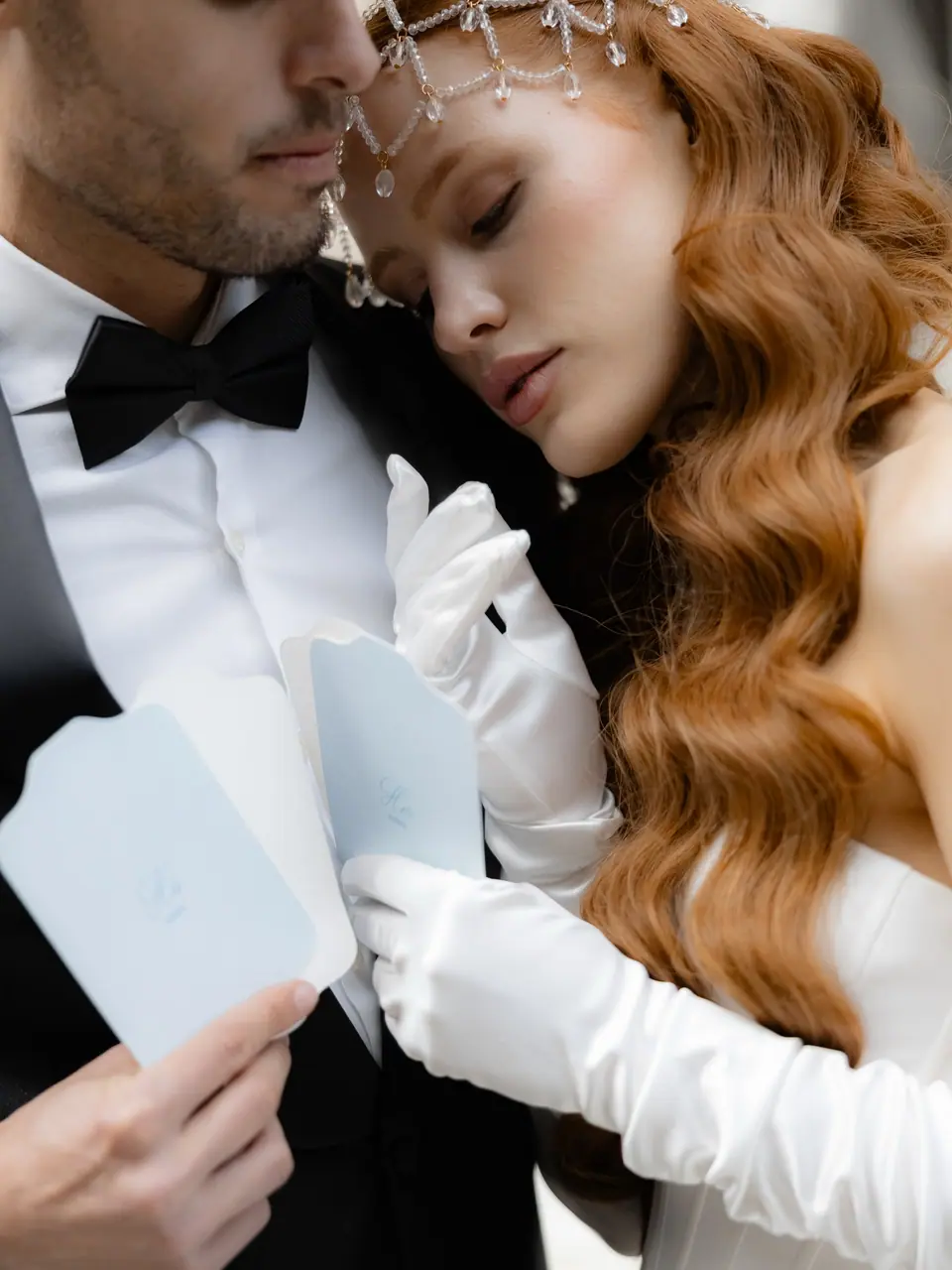 Antoine and Roberta close together, holding pale blue cards